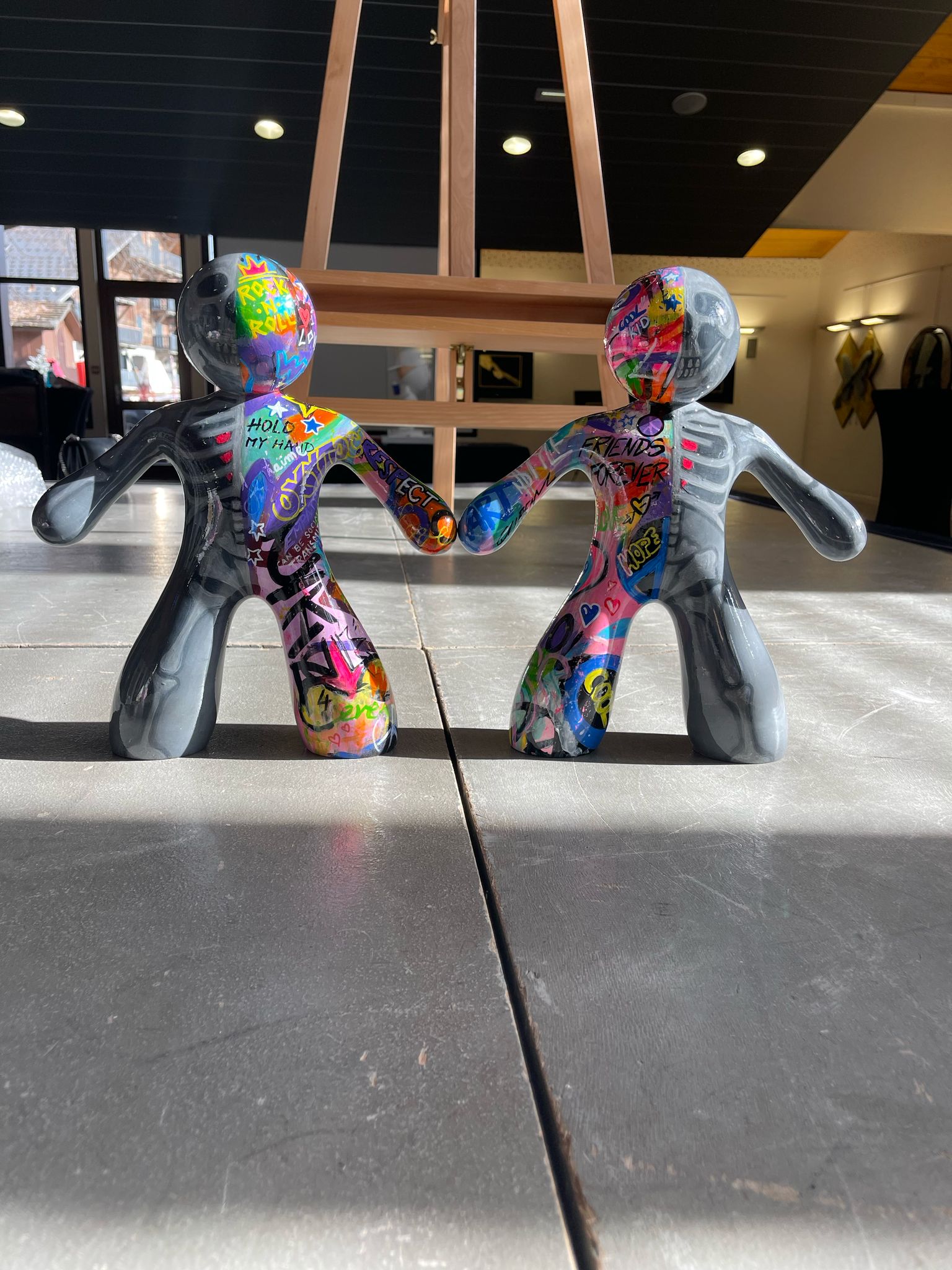 Sculptures Ni-Zu ( My sculptural series, Ni-Žu, features stylized human figures joined by hidden magnets in their hands — a symbol of biomagnetic connection and the invisible energy that links us all. One half is neutral grey — calm and balanced — the other, a vivid graffiti expression of love, peace, family, and respect.)